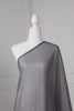 Dark grey saree draped on a mannequin. The saree has silver threading sewn throughout, giving a shimmery appearance.