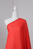 Bright red saree draped on a mannequin. The saree has silver threading sewn throughout, giving a shimmery appearance.