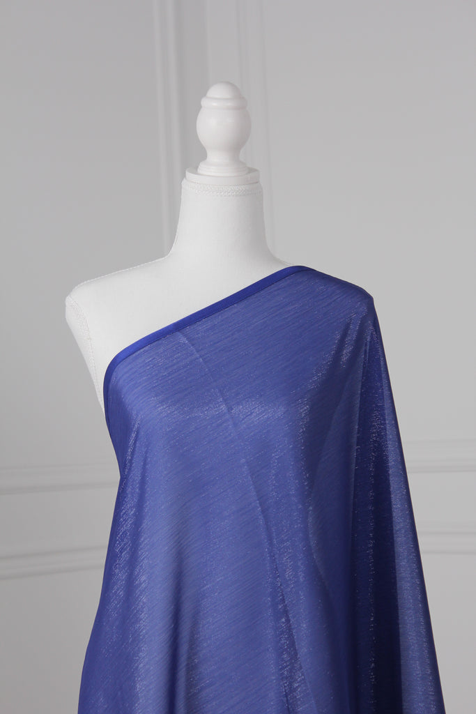 Royal blue saree draped on a mannequin. The saree has silver threading sewn throughout, giving a shimmery appearance.